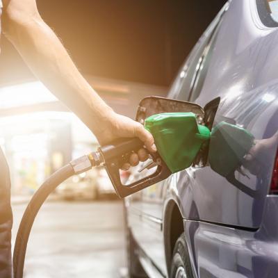 Gray car at gas station being filled.