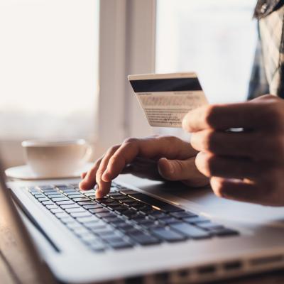 Man holding credit card and using laptop