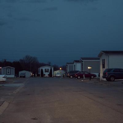 Dusk falls on cars parked next to mobile homes in a mobile park owned by a private equity firm in Smyrna, Tennessee. 