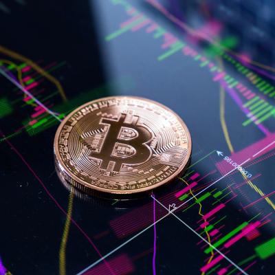 Gold bitcoin on top of finance graphic charts.