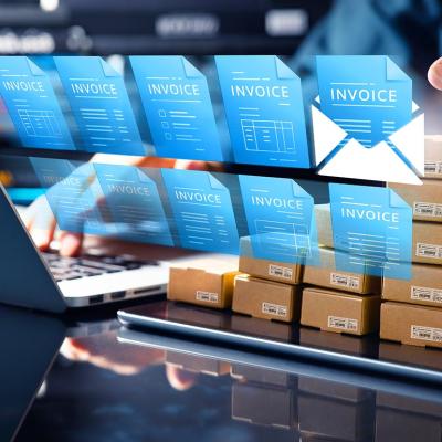 Concept of technology in accounting illustrated by 10 blue virtual invoice icons superimposed over person using a laptop computer.