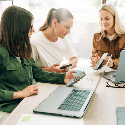 Three businesswomen in a meeting discussing marketing strategies.