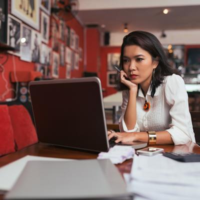 A female bar owner using her laptop to pay business expenses online.