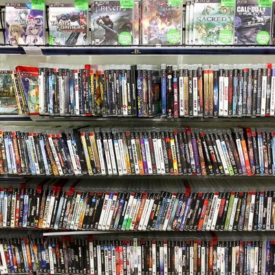 PlayStation game discs on display at a game store.