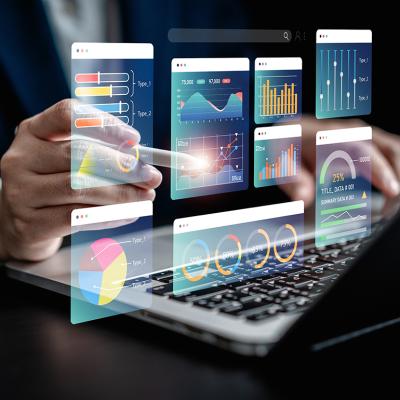 Businessman using a laptop with illustratons of finance software, charts and dashboard graphics.