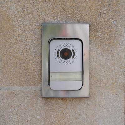 A surveillance video doorbell on a modern house's door.