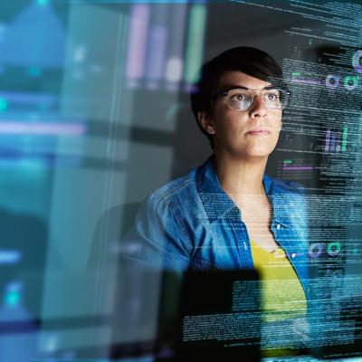 A young female computer programmer looking through data.