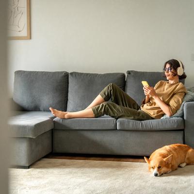 A young woman lying on couch while listening to music with her headphones.