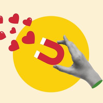 A custom illustration of a hand holding a magnet pulling hearts.