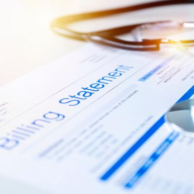 A close up on a healthcare billing statement document with a stethoscope on top.