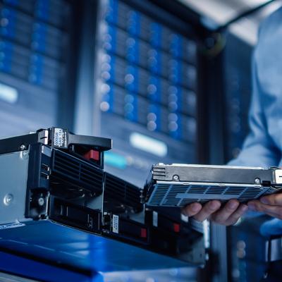 An IT engineer preparing to install new hardware into a server pack.