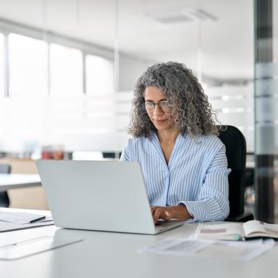 Older woman working at a computer.