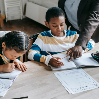 A tutor helping two young students.