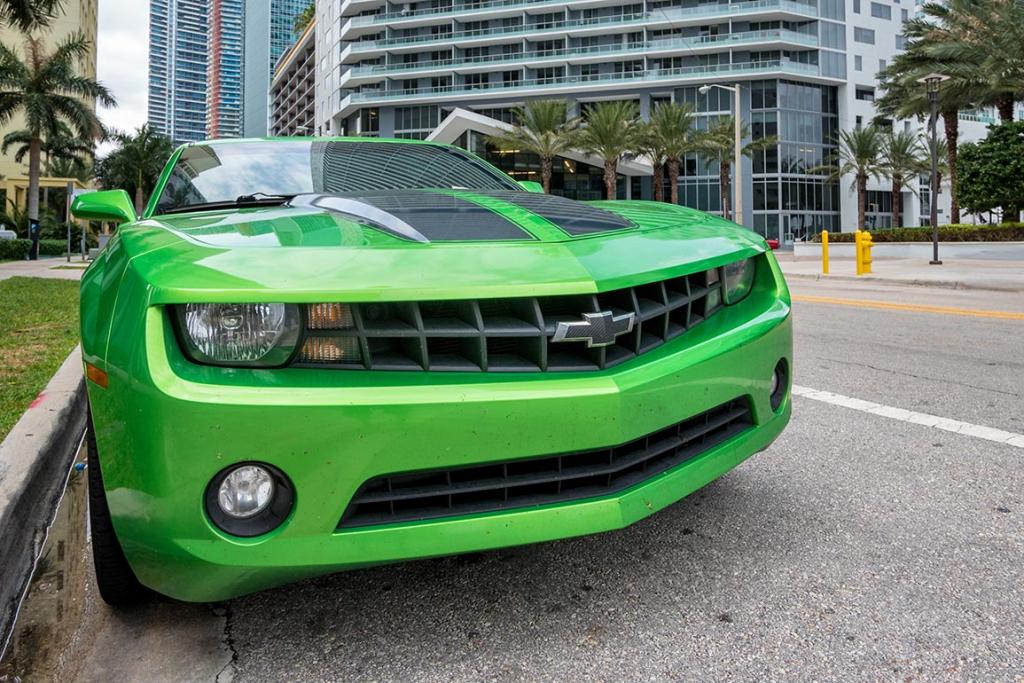 Low angle front view of Green Chevrolet Camaro sports car parked in the street in Miami.