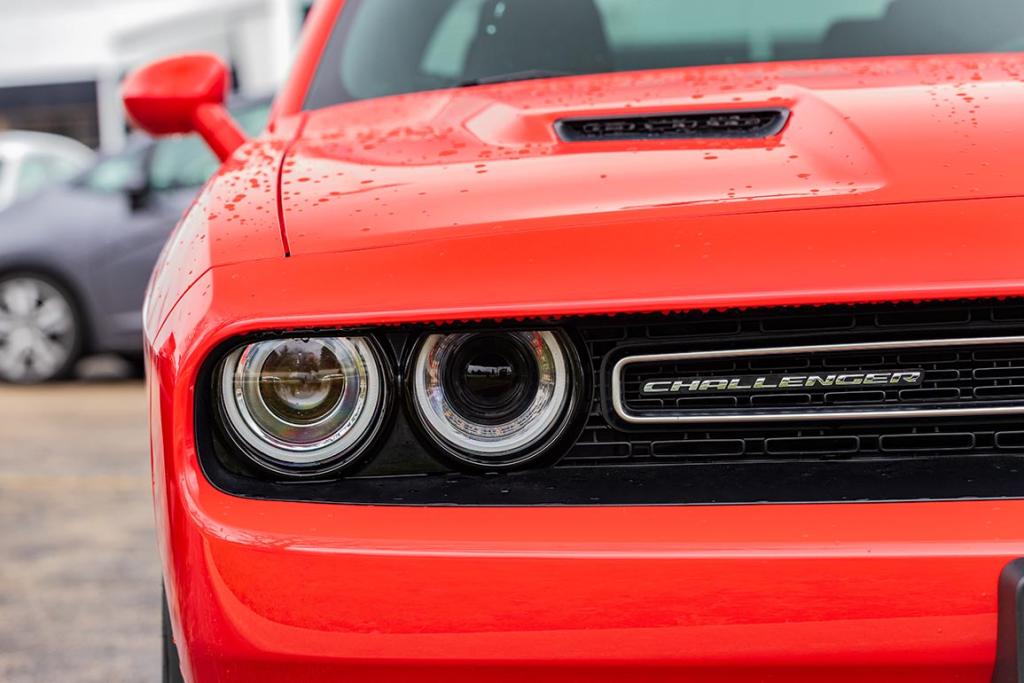 The front of a Go Mango colored 2018 Dodge Challenger R/T Scat Pack, which features 485 horsepower with its 6.4L engine. 