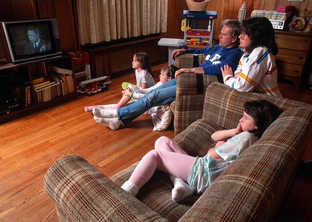 A family of five in 1991 watching a television show in their living room.