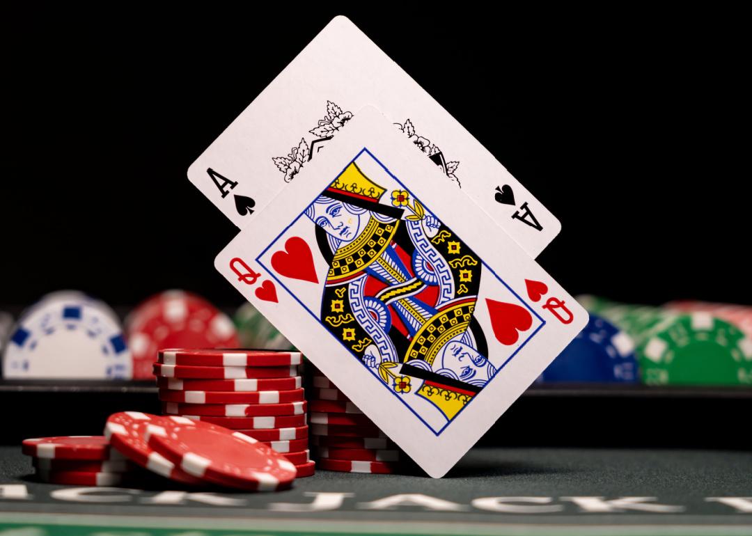 Queen and Ace cards above blackjack table.