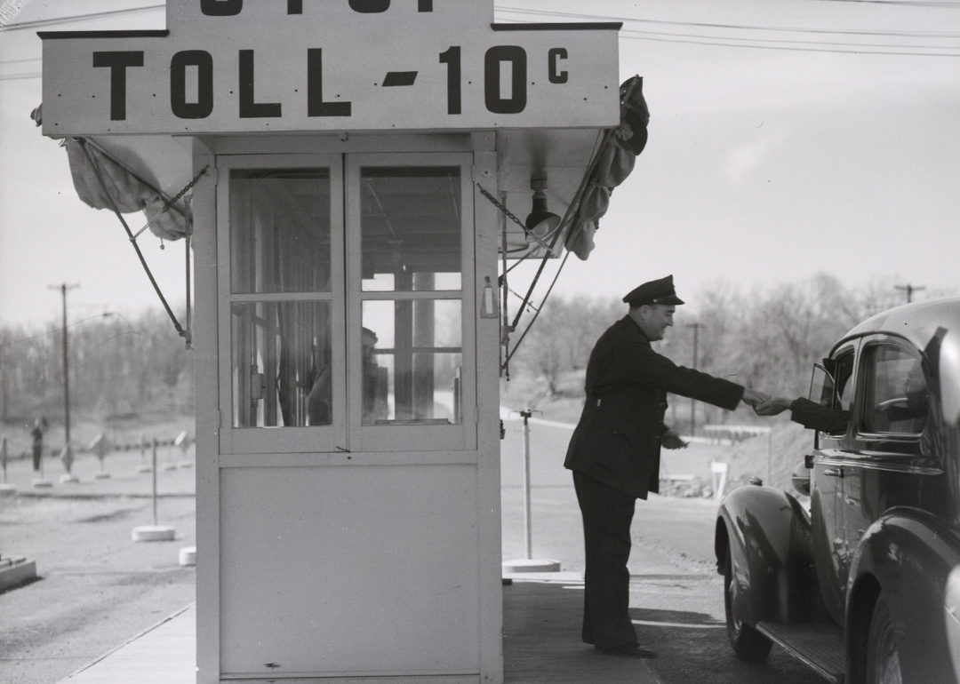 Toll collector at booth with sign