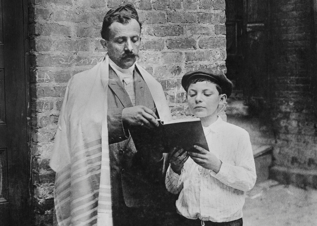 A vintage photo of a father and son reading a book.