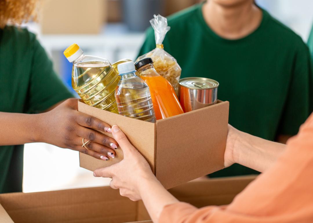 Person handing food donation box.