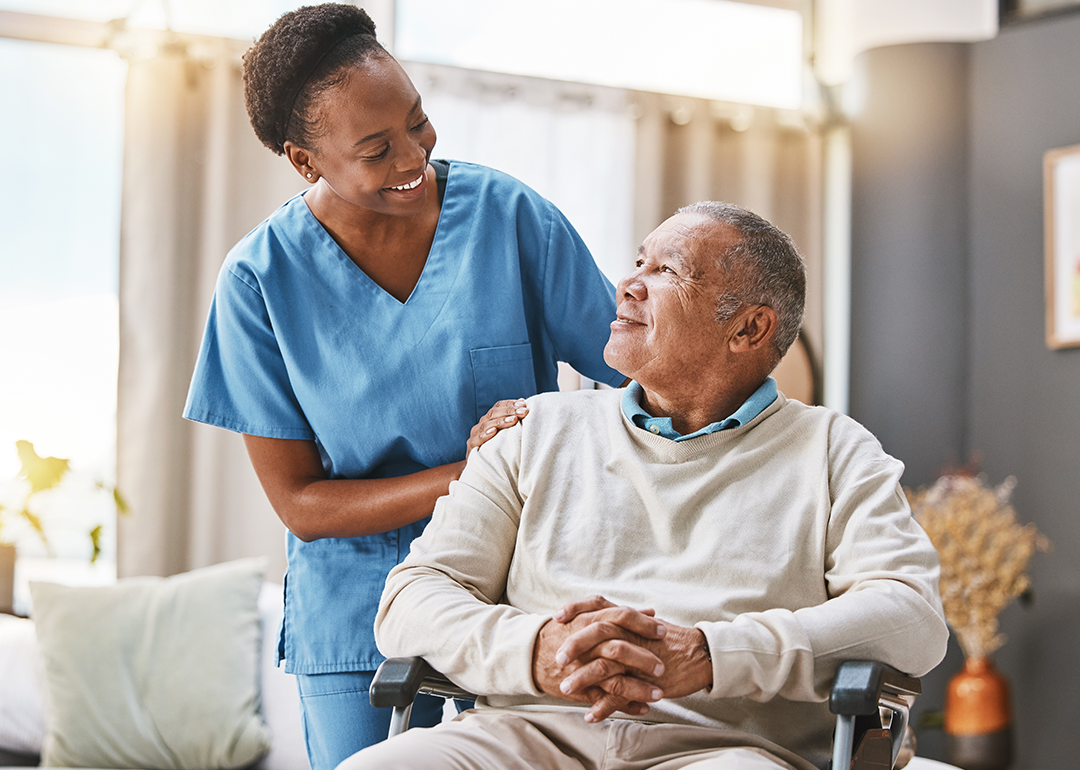 Nurse assisting a man in wheelchair.