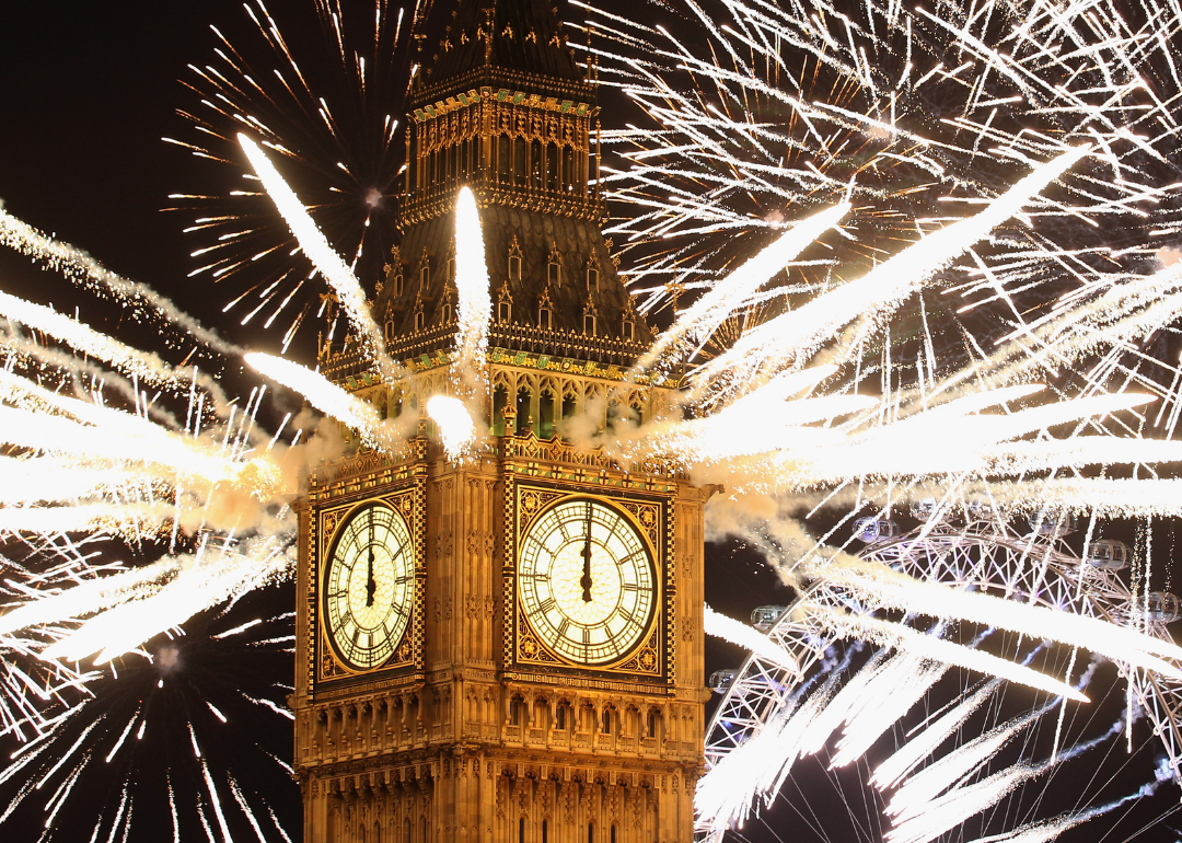Fireworks coming out of the top of a clock tower. 