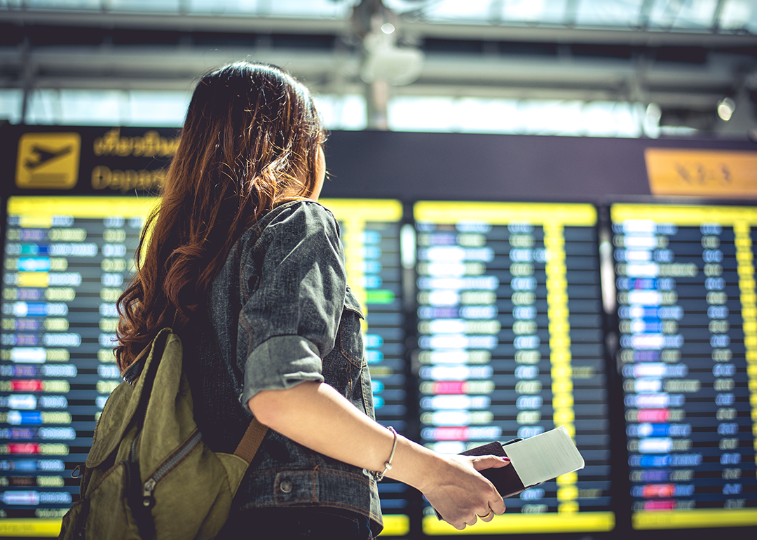 A person looking at departures board in airport.