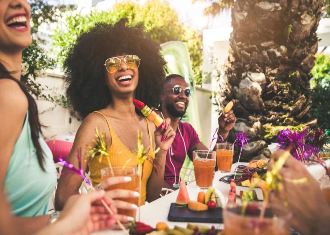 A group of friends enjoying food and drinks in a backyard.