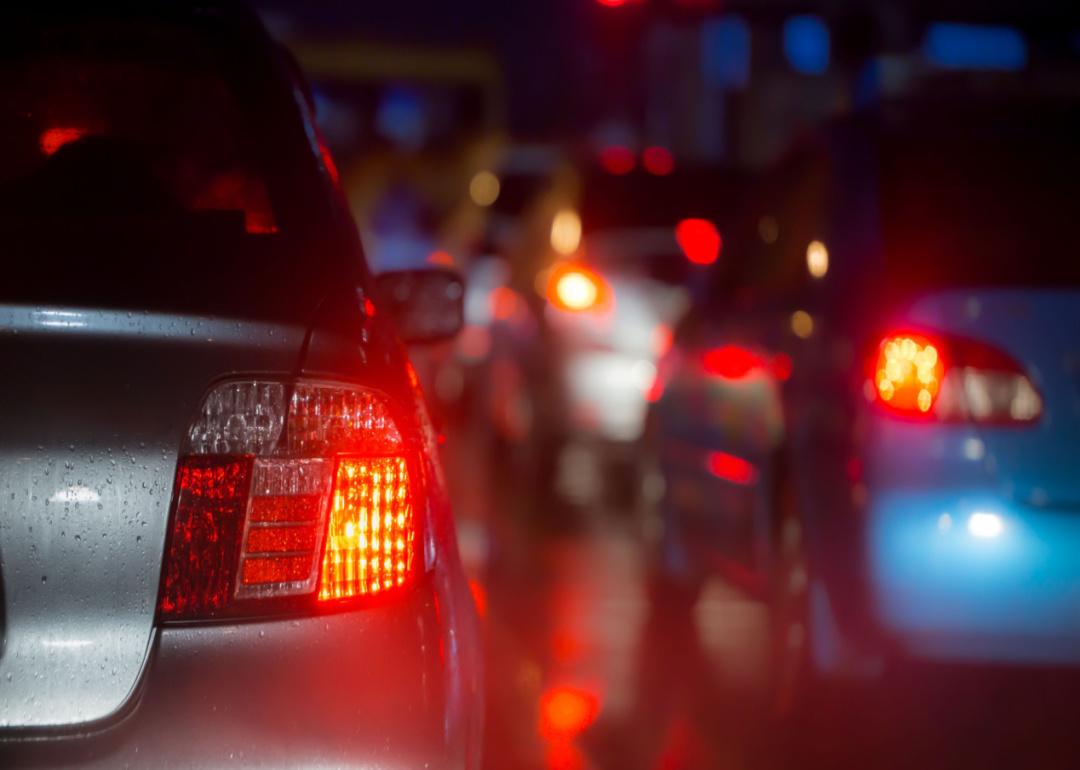 Red car brake lights on busy road at night  