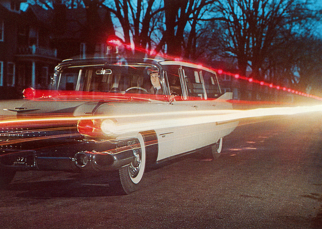 Light trails from a 1950s Cadillac ambulance driving on a road.