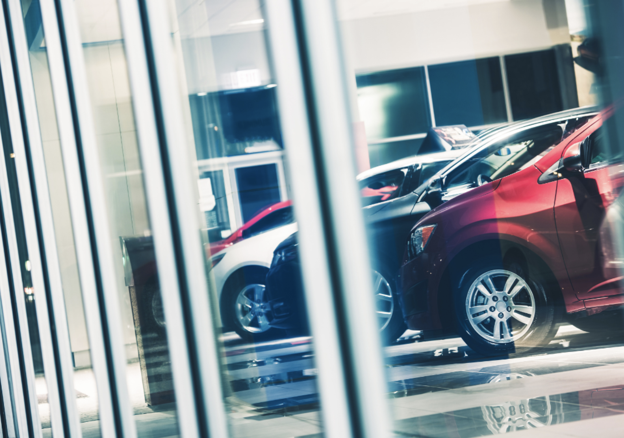 Used vehicles through showroom window.