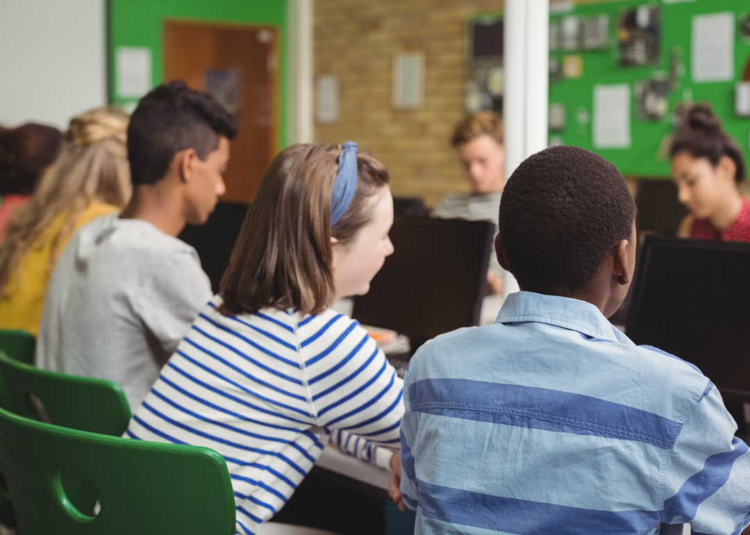 Students in a classroom listen to their teacher