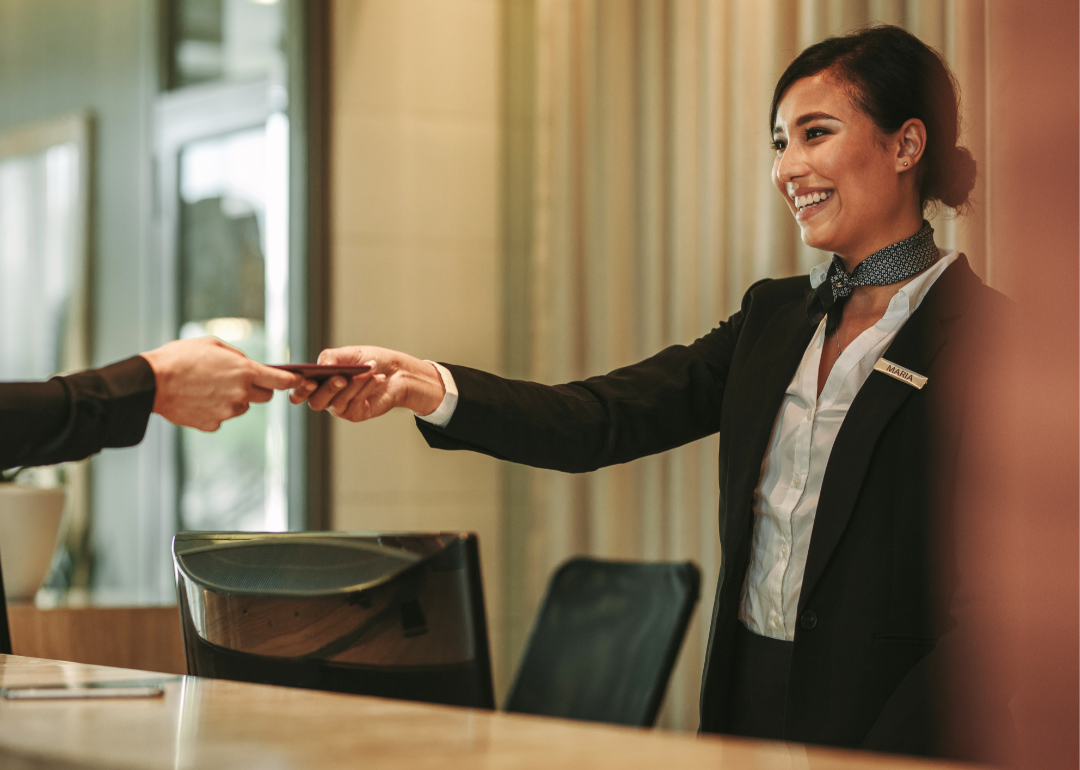 Receptionist at the hotel giving a guest a key.