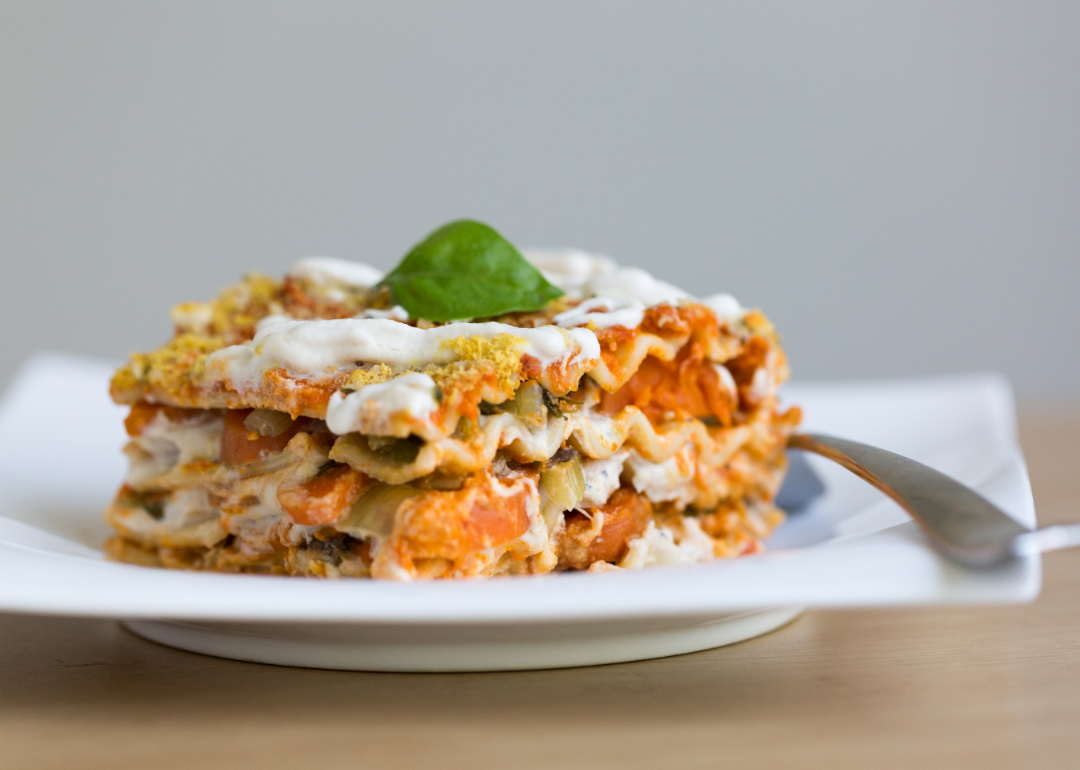 A piece of vegan lasagna on a white square plate.
