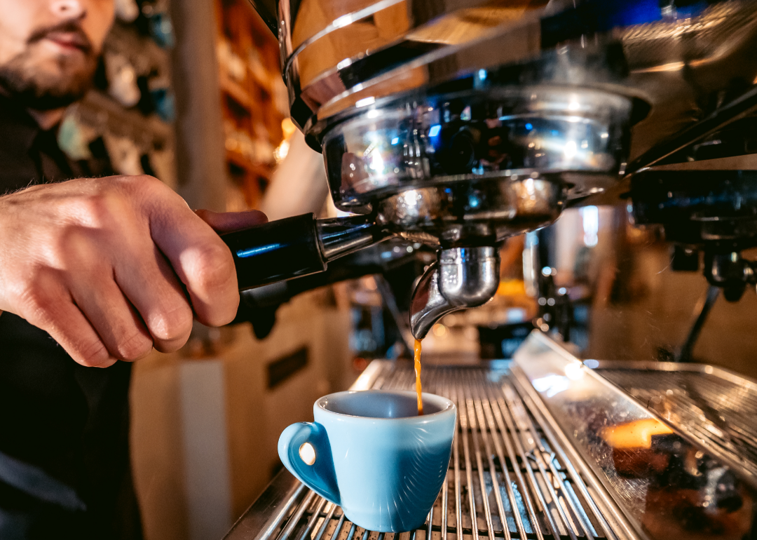 The hand of a barista making an espresso coffee.