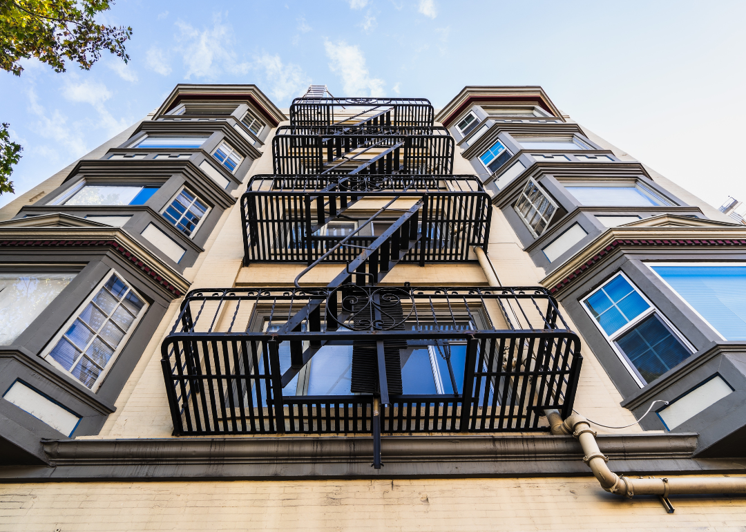 Exterior of apartment building with windows and fire escapes