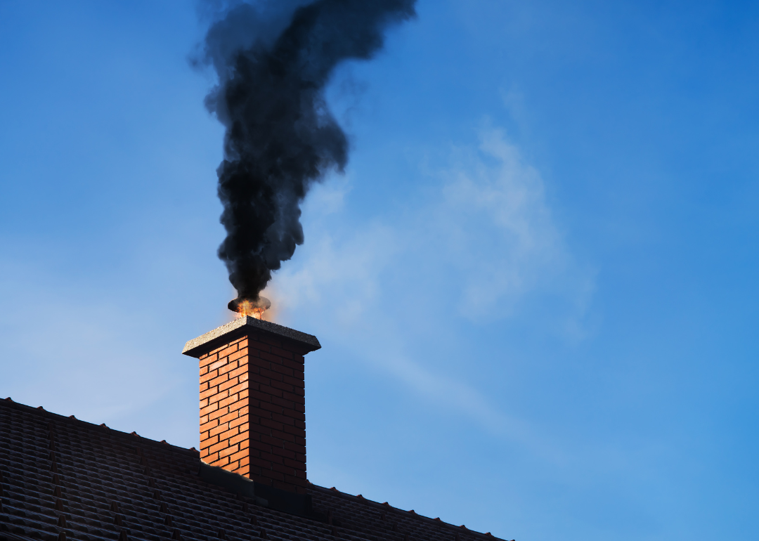Black smoke coming out of a chimney on a residential home due to fire