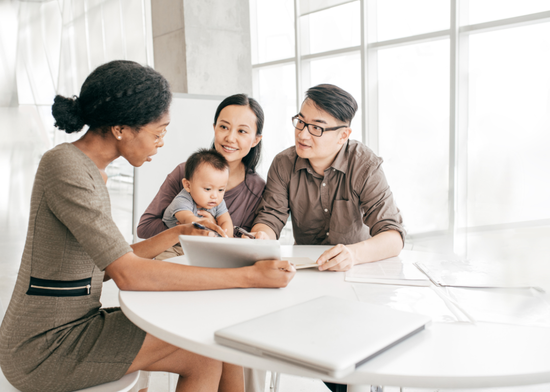 A young family sits at a table working with a financial consultant