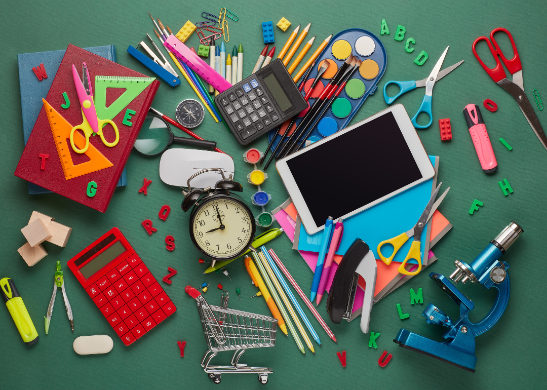 An assortment of school supplies on a green background