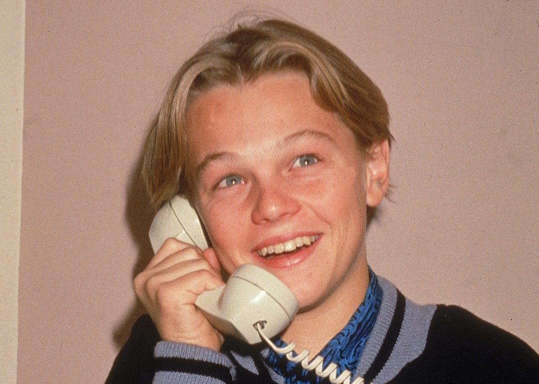 A young Leonardo DiCaprio poses for a picture while talking on a telephone, circa 1989