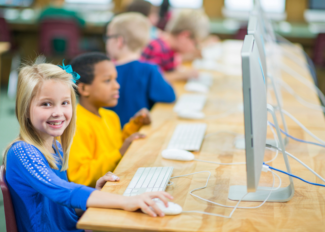 Kids in a computer lab sitting in front of desktop computers