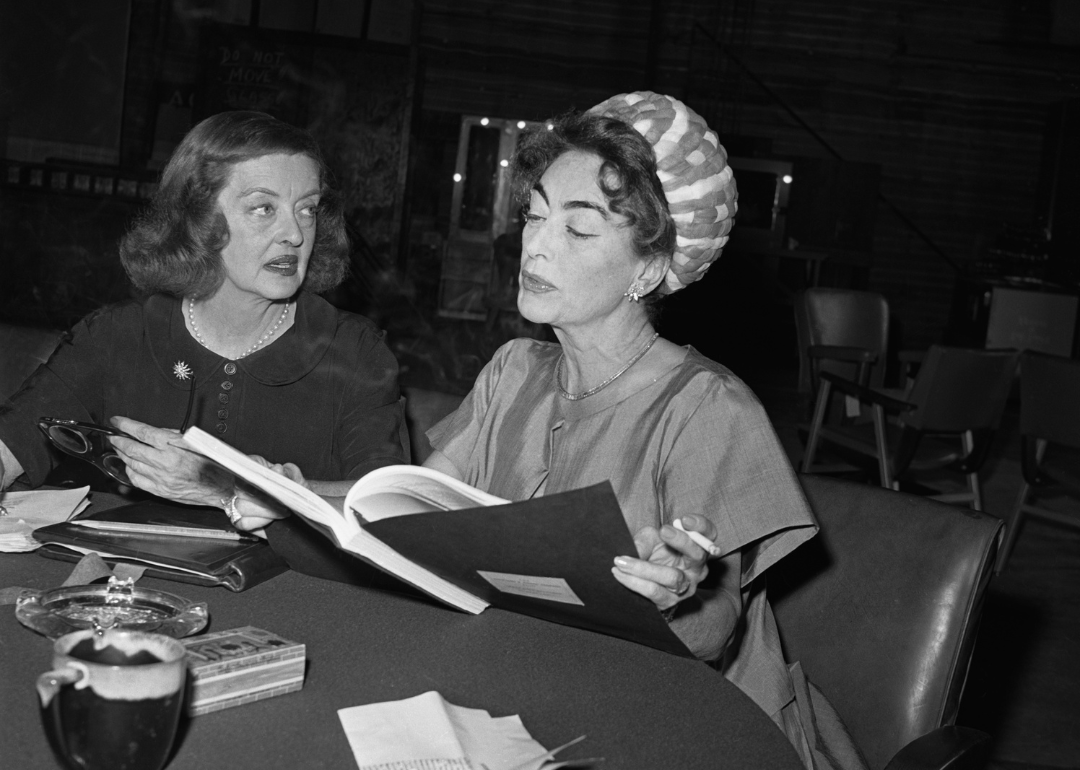Bette Davis (L), and Joan Crawford are photographed as they look over the script of the film, What Ever Happened to Baby Jane?, in which they will co-star, circa 1962.