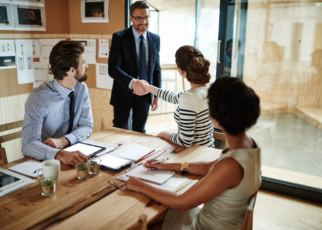 Two people shake hands at a business meeting