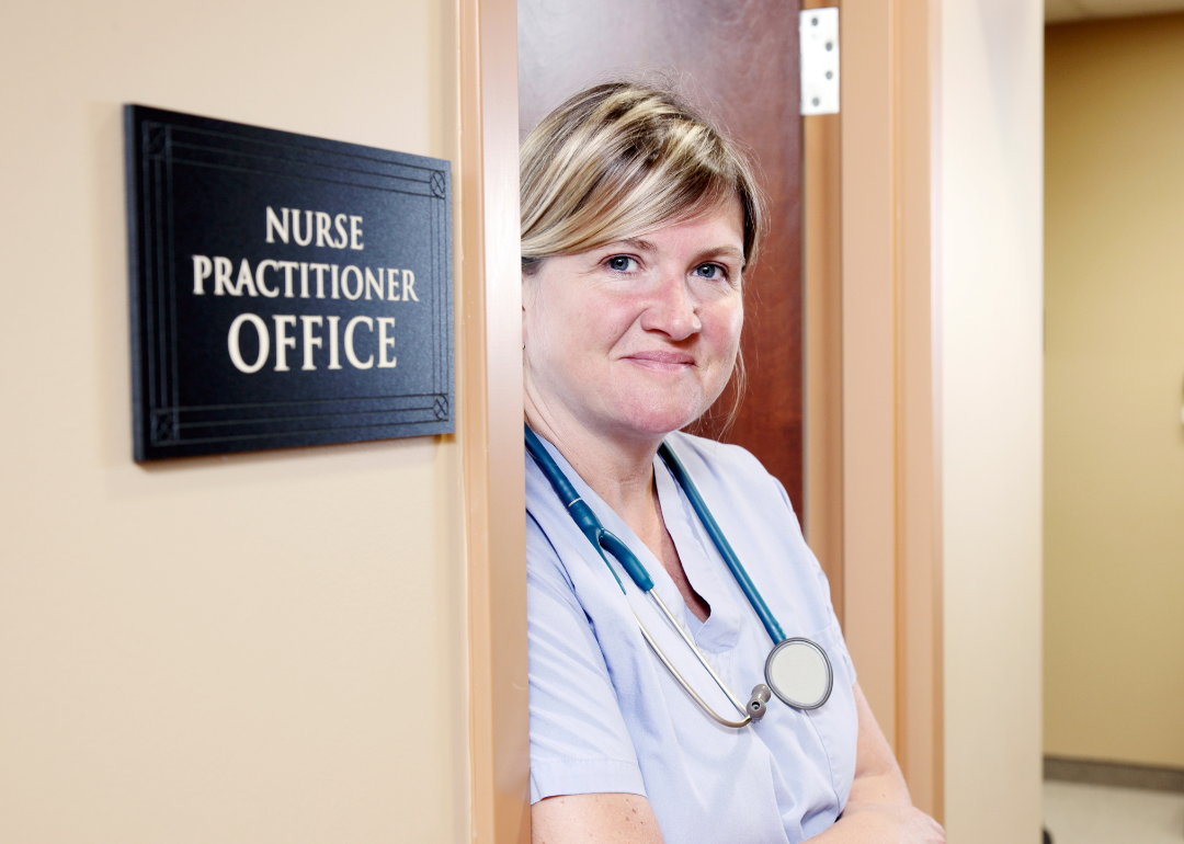A nurse practitioner stands in the doorway of her office