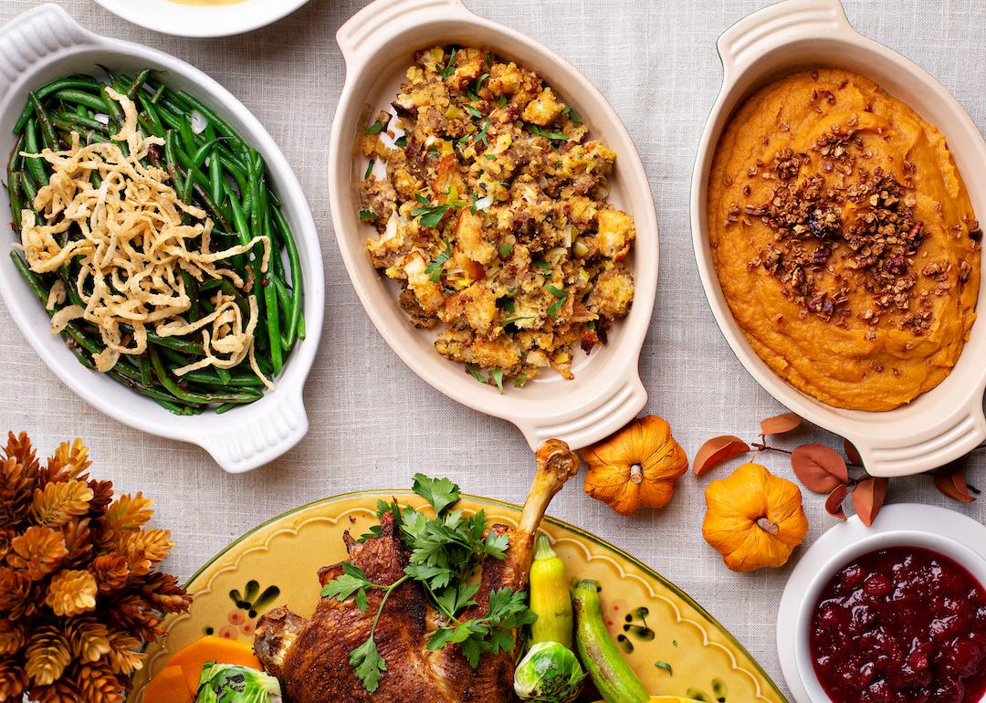 Casserole dishes of green beans, stuffing, and sweet potatoes.