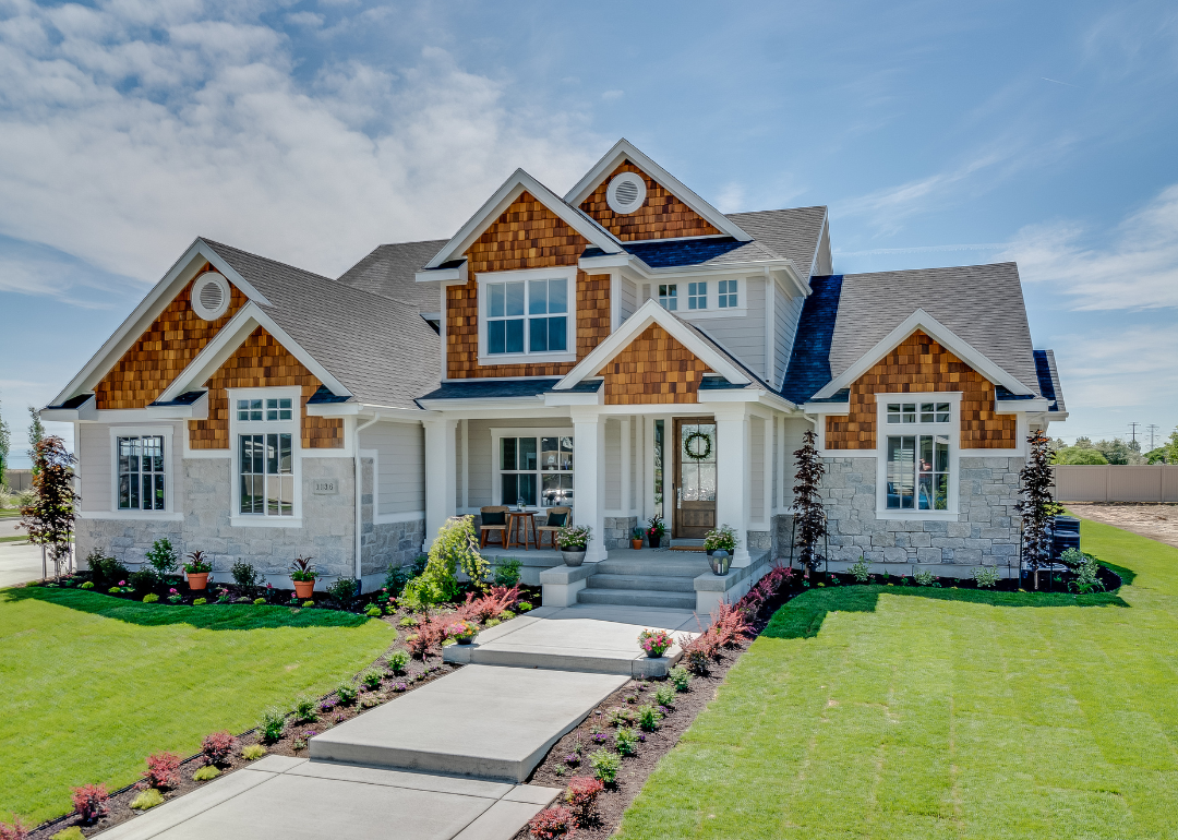 A large home centered in a green lawnscape