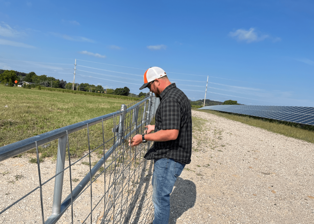 image of Operations manager Bart Hautala closes the gate at the Heritage Sustainable Energy solar array in Traverse City, Michigan.
