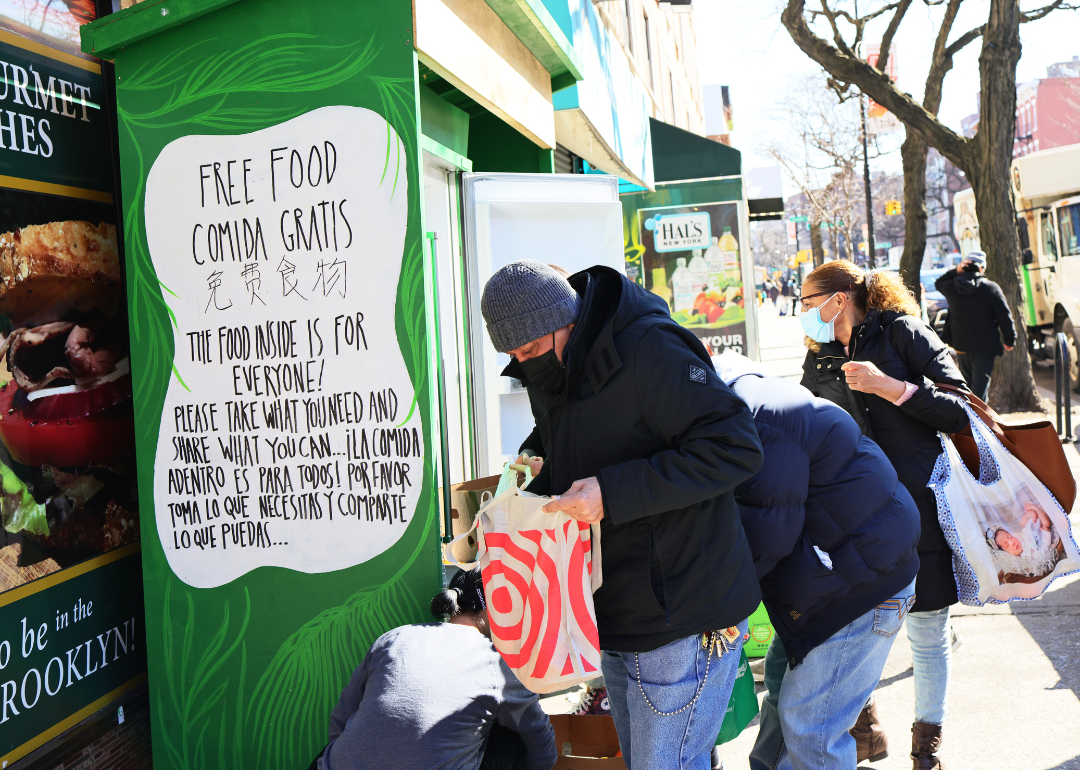 People pick up food from the Clinton Hill-Fort Greene Mutual Aid group's refrigerator on March 03, 2021 in the Fort Greene neighborhood of the Brooklyn borough in New York City.