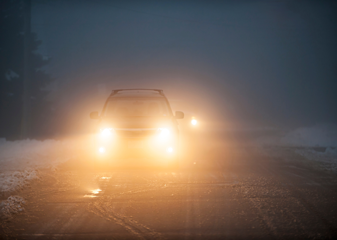 A car driving in foggy conditions with headlights on
