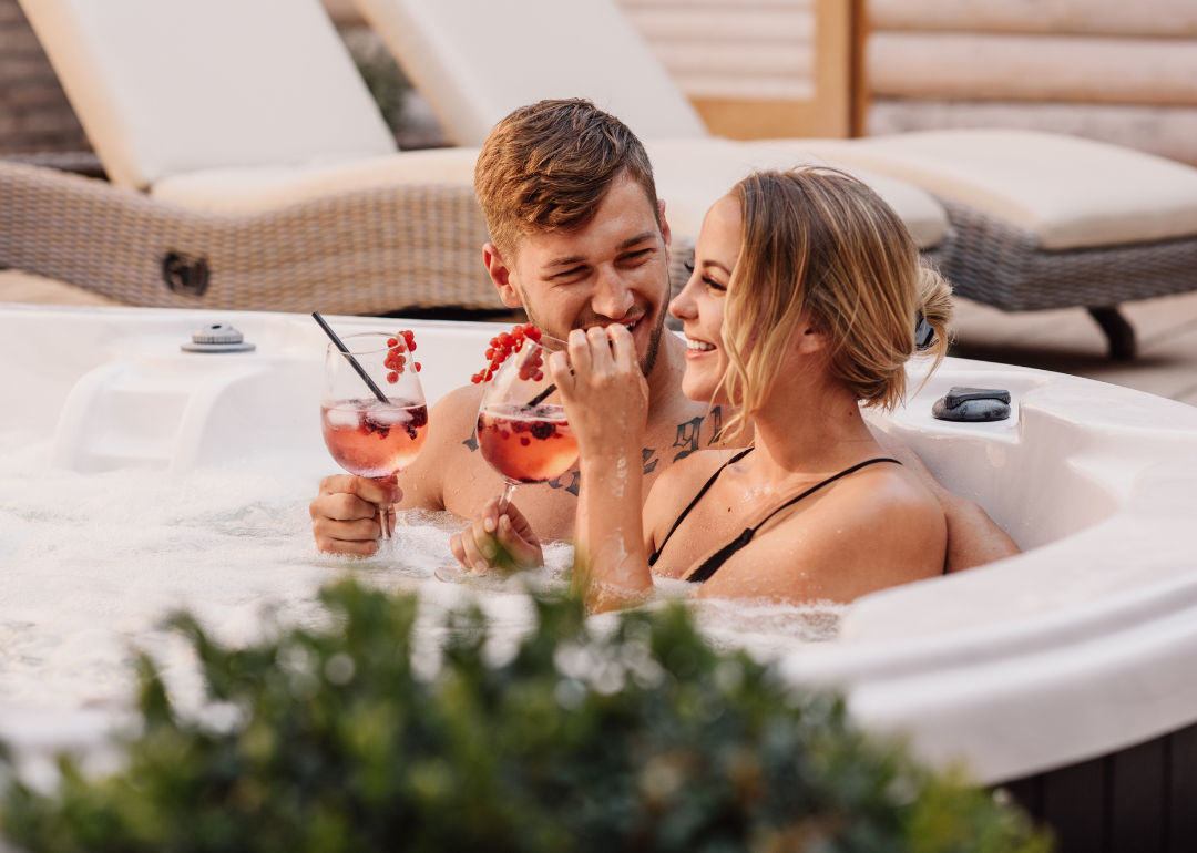 A couple sipping drinks in a hot tub